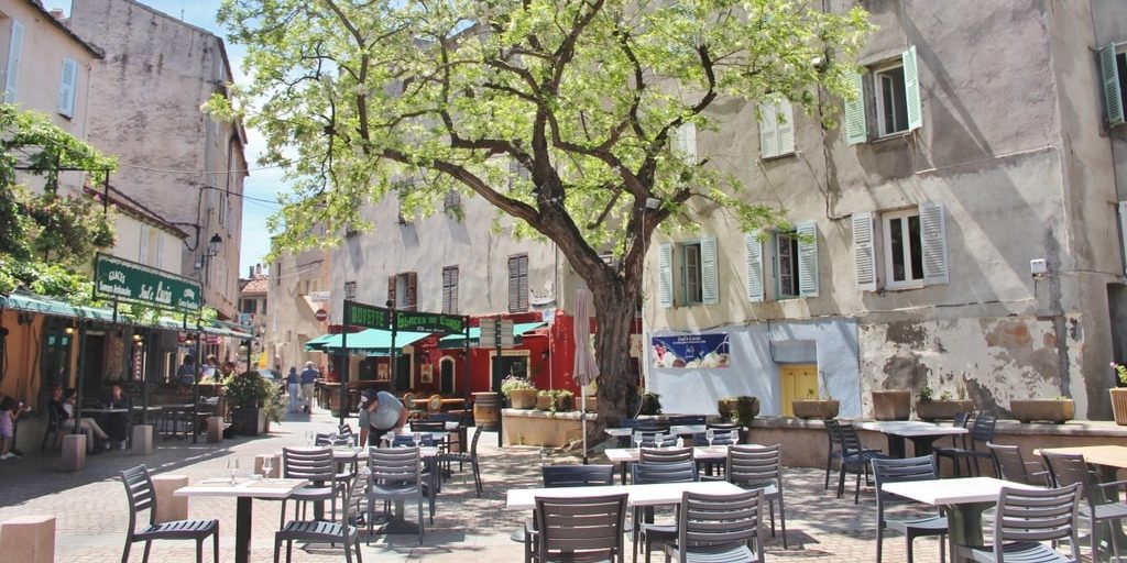 Hotel La Roya Saint-Florent Corsica Frankrijk stadje plein boom terras schaduw