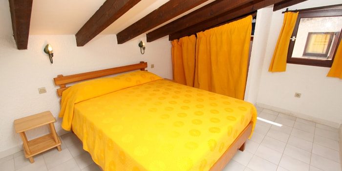 Residence maina Cargese Corsica Frankrijk appartementen slaapkamer tweepersoonsbed geel